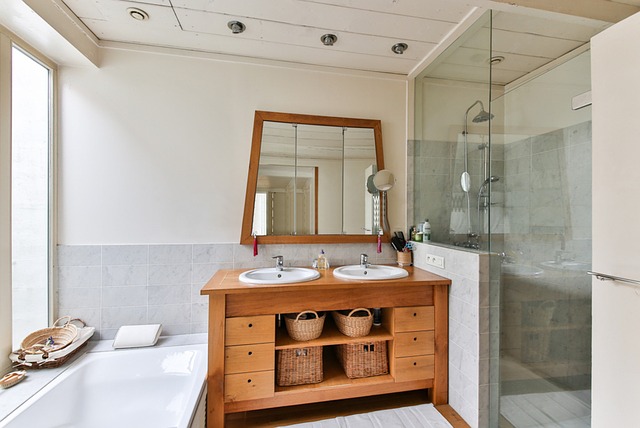 Priestranná kúpeľňa s dreveným nábytkom a preskleným sprchovacím kútom.jpg